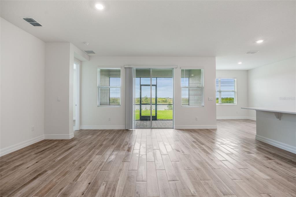 2277 Hamden Way Mount Dora, FL 32757 - Photo 22 of 32 a view of an empty room with wooden floor and a window