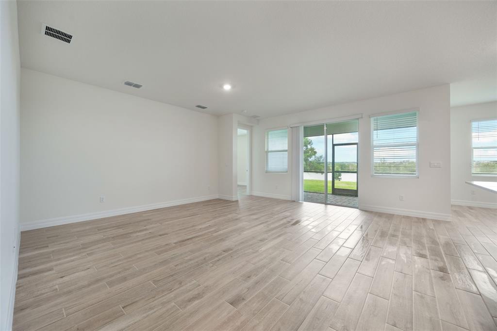 2277 Hamden Way Mount Dora, FL 32757 - Photo 23 of 32 a view of an empty room with wooden floor and a window