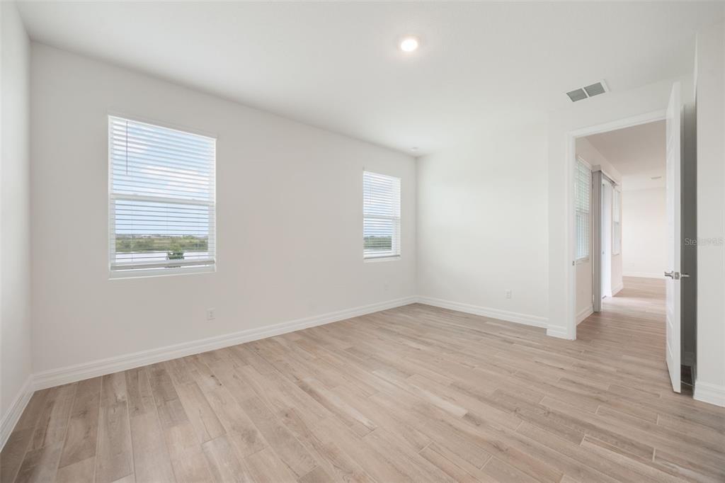 2277 Hamden Way Mount Dora, FL 32757 - Photo 26 of 32 an empty room with wooden floor and windows