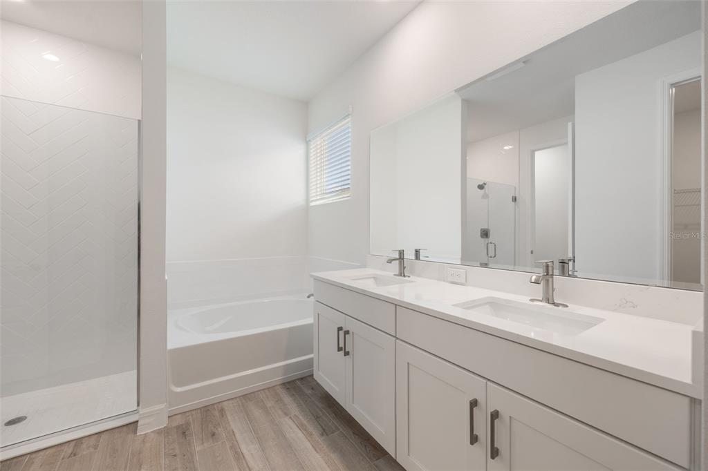 2277 Hamden Way Mount Dora, FL 32757 - Photo 27 of 32 a bathroom with a double vanity sink and mirror with shower