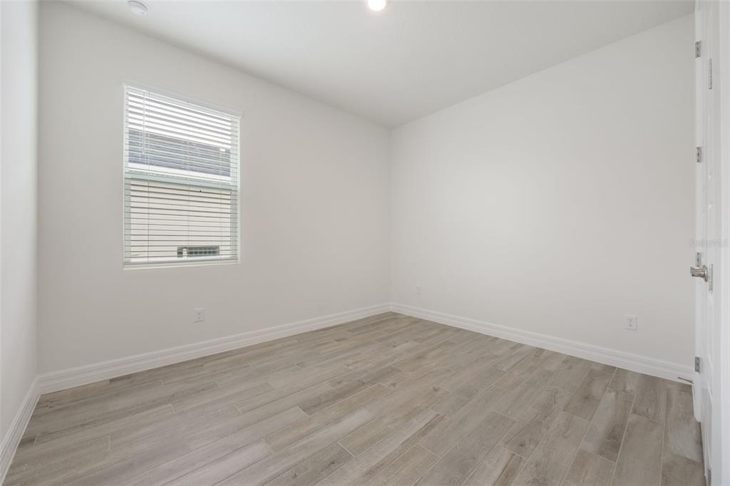 2277 Hamden Way Mount Dora, FL 32757 - Photo 9 of 32 an empty room with wooden floor and a window