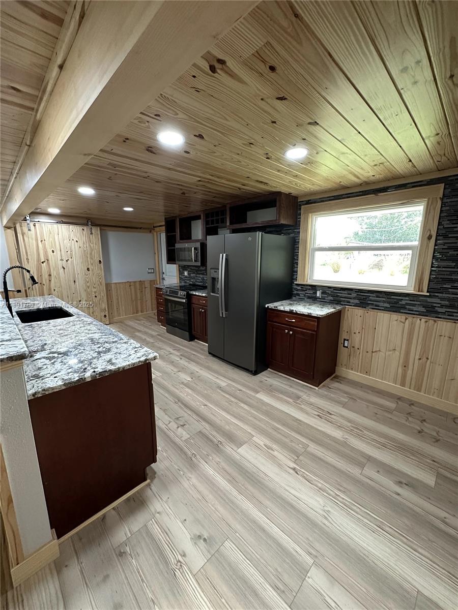 111 Springdale Road Sebring, FL 33870 - Photo 8 of 50 a large kitchen with stainless steel appliances granite countertop a large counter top and a wooden floors