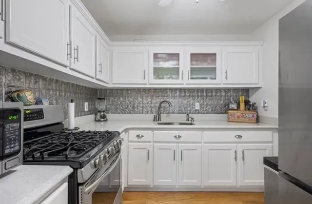 a kitchen with white cabinets and appliances