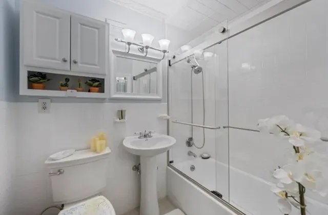 a bathroom with a sink a toilet and shower