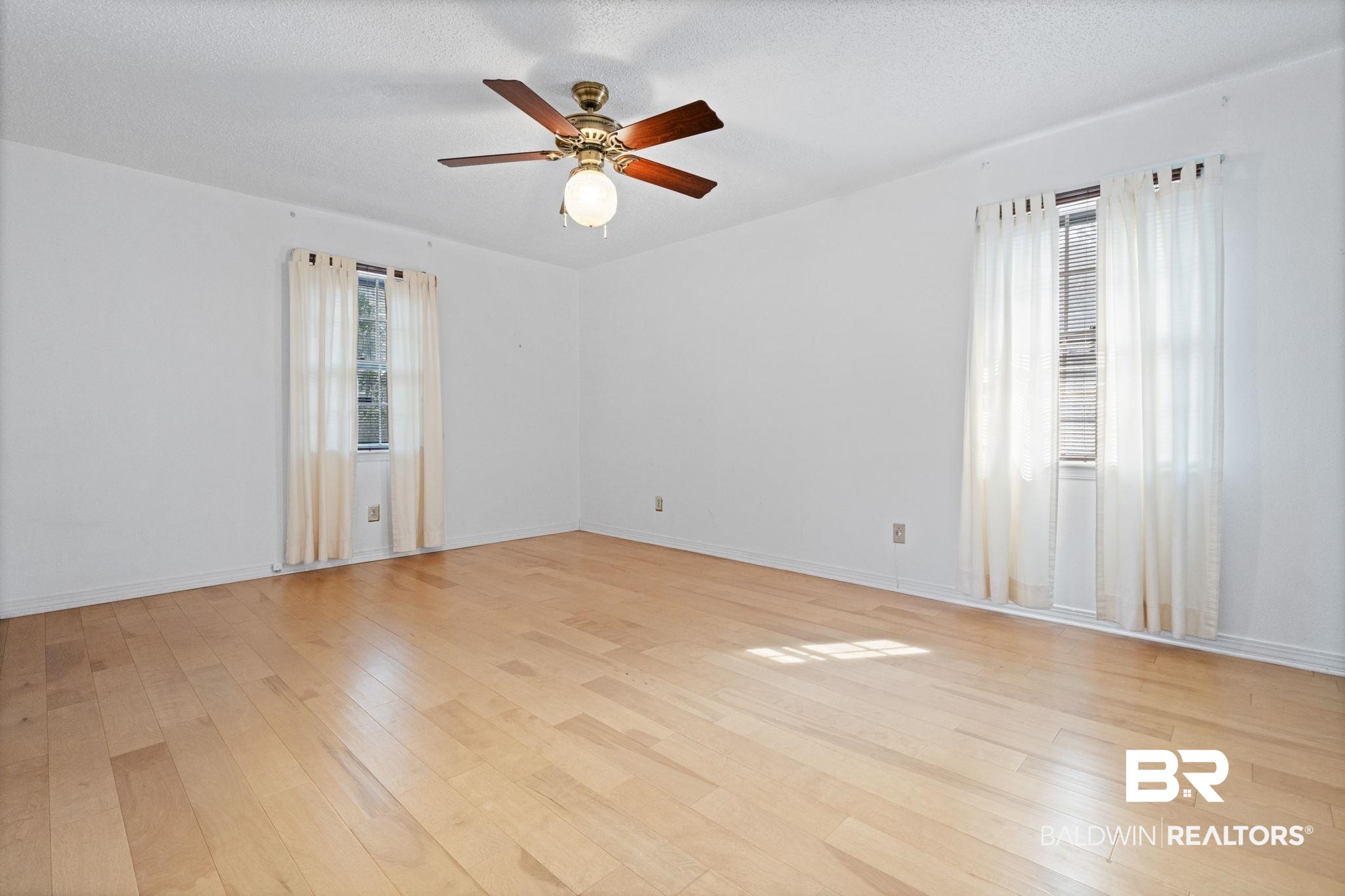 6261 Old Pascagoula Road Theodore, AL 36582 - Photo 25 of 29 Spare room featuring ceiling fan, a textured ceiling, light hardwood / wood-style flooring, and a healthy amount of sunlight