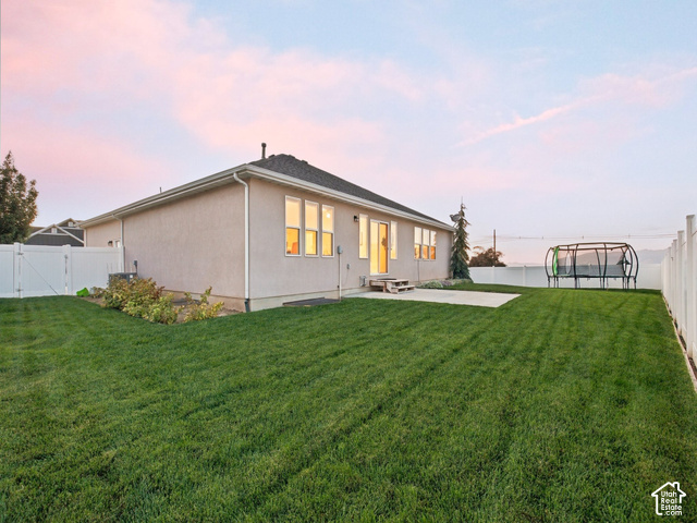 1288 North Horizon View Loop Elk Ridge, UT 84651 - Photo 32 of 38 Expansive backyard featuring a manicured lawn, concrete patio, white vinyl fencing, and mature landscaping
