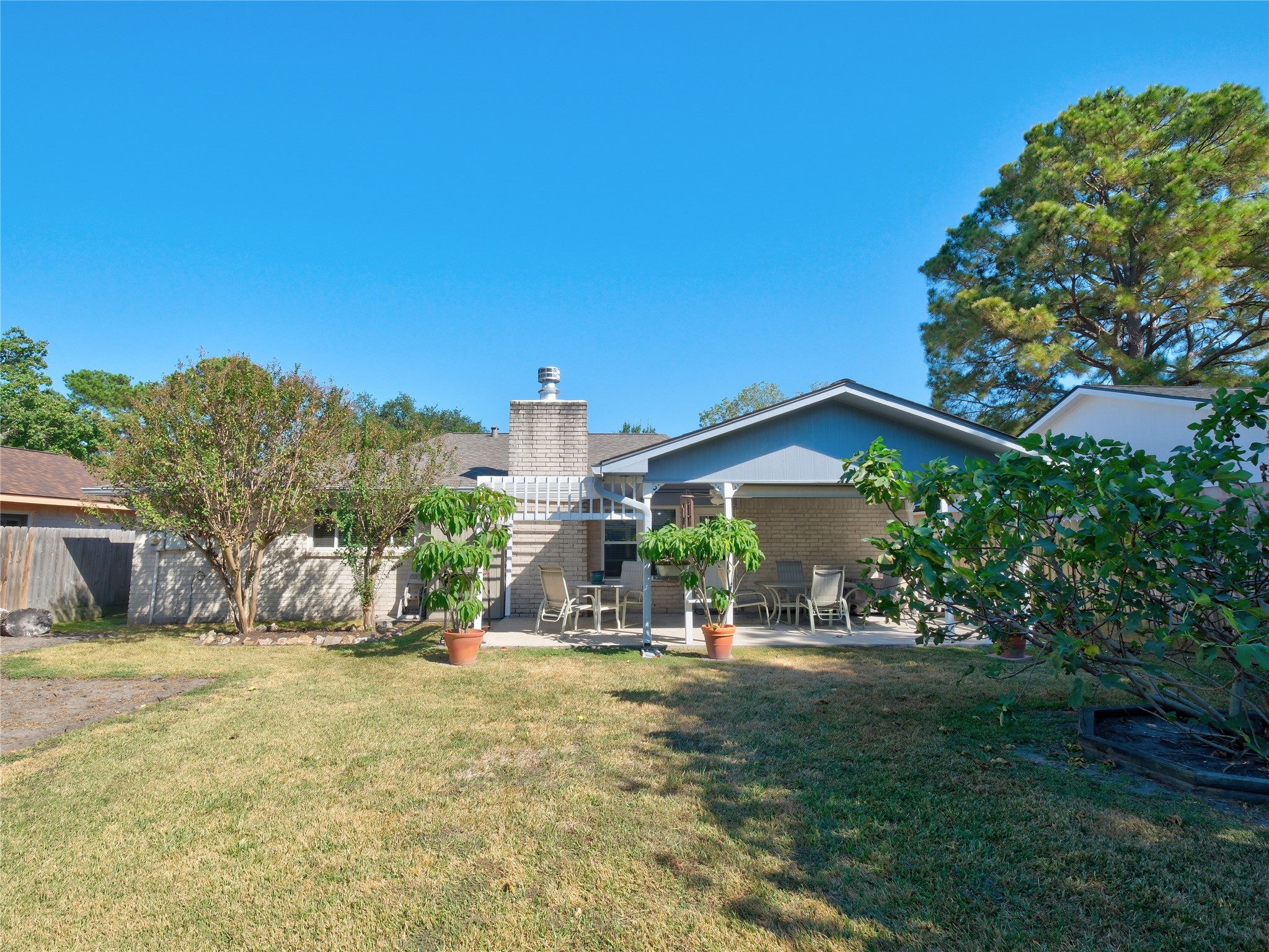 7315 Weatherhill Lane Houston, TX 77041 - Photo 35 of 40 This spacious backyard with lush greenery, a covered patio, and outdoor seating area.