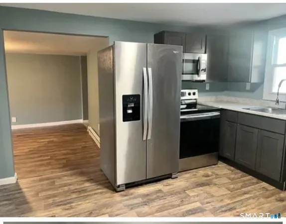 a kitchen with stainless steel appliances granite countertop a refrigerator and a sink