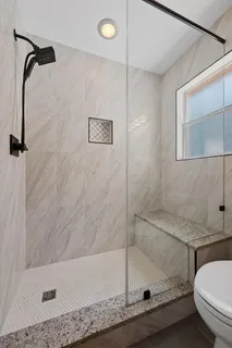a bathroom with a granite countertop sink a toilet and bathtub