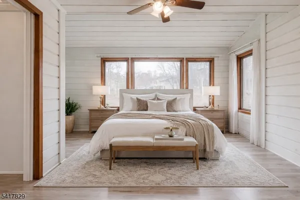a bedroom with a bed lamp and a large window