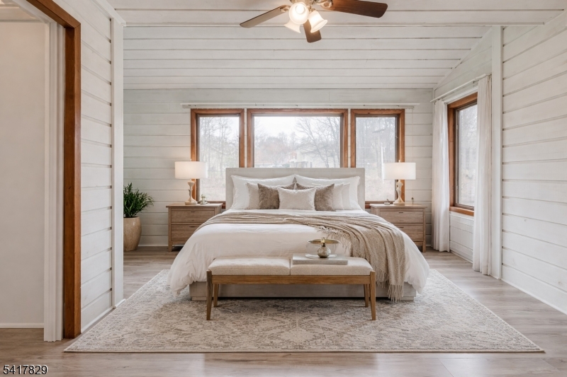 a bedroom with a bed lamp and a large window