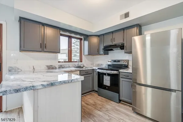 a kitchen with stainless steel appliances granite countertop a refrigerator stove a sink and dishwasher