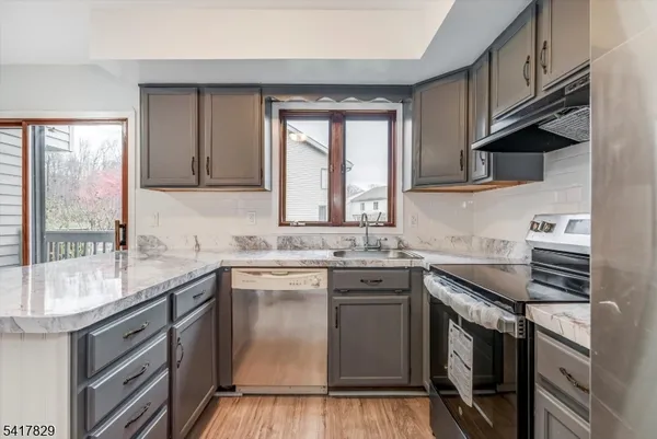 a kitchen with stainless steel appliances granite countertop a sink stove and cabinets