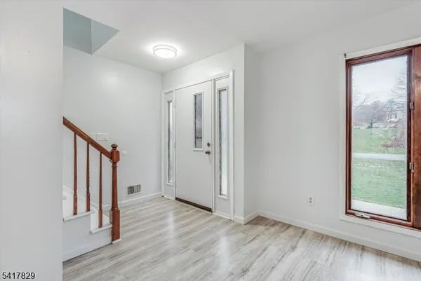 an empty room with wooden floor and a window