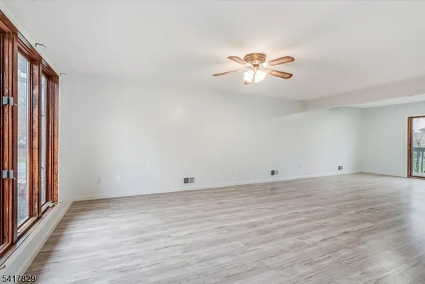 a view of a room with wooden floor and a ceiling fan