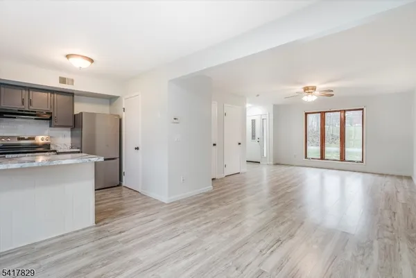 a view of kitchen with stainless steel appliances refrigerator oven and cabinets