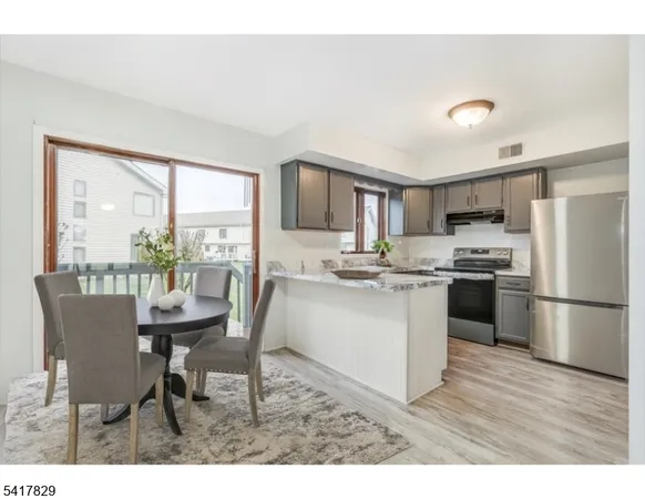 a kitchen with a table chairs refrigerator and microwave