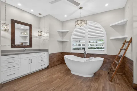 a spacious bathroom with a double vanity sink a mirror and a bathtub