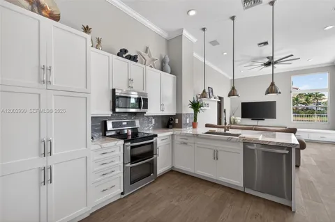 a kitchen with stainless steel appliances granite countertop a sink a stove and a refrigerator