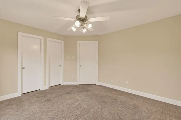 a view of an empty room with a chandelier fan
