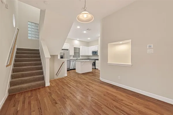 a view of a room with wooden floor and white walls