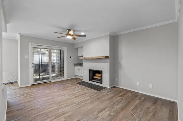 wooden floor fireplace and windows in an empty room