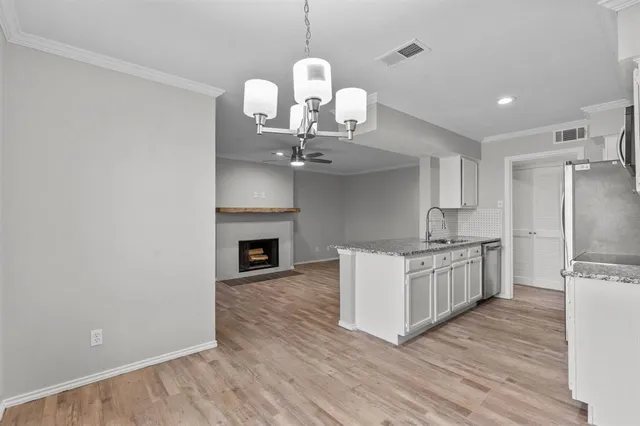 a kitchen with granite countertop a stove oven and a wooden floor