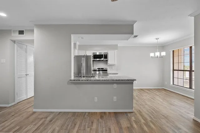 a view of kitchen with granite countertop cabinets and wooden floor