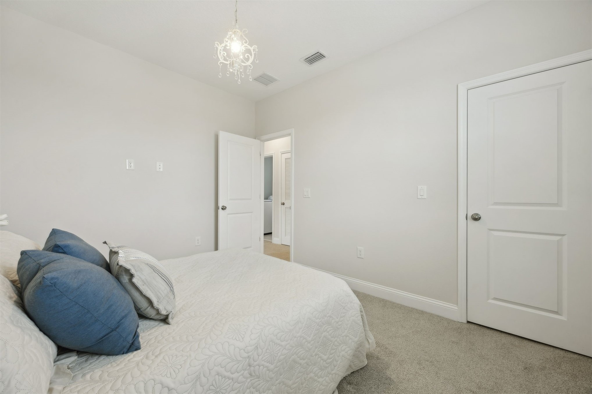 141 Redbud Lane Yulee, FL 32097 - Photo 41 of 61 a bedroom with a bed and a chandelier