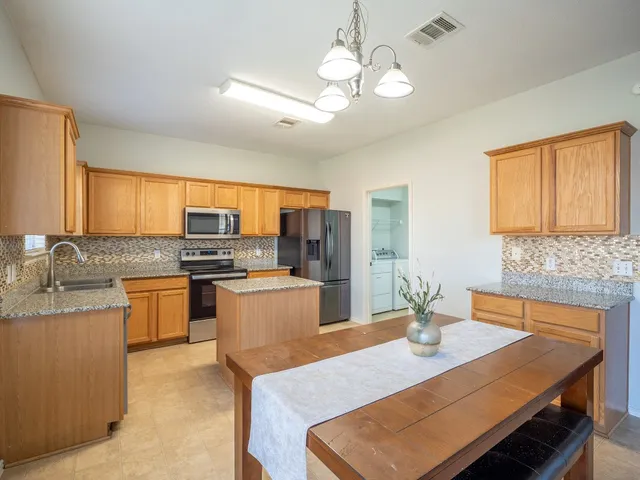 a kitchen with stainless steel appliances granite countertop a sink stove and refrigerator