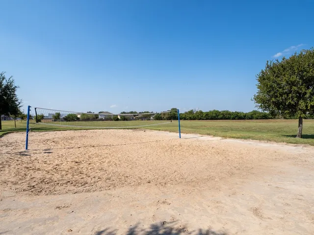 a view of pool with lawn chairs under an umbrella