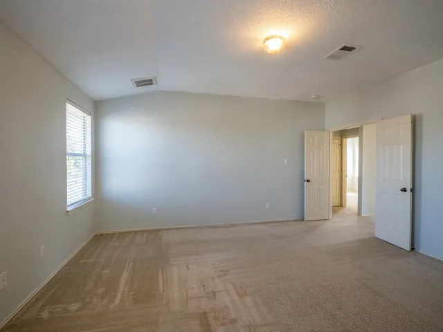 an empty room with windows and closet