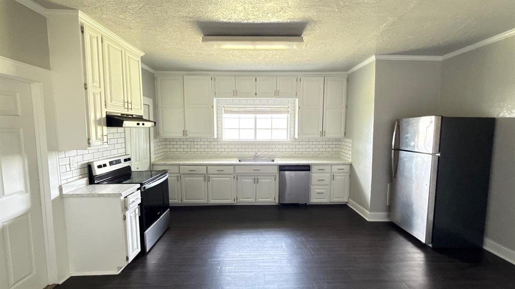1338 State Highway 121 Bonham, TX 75418 - Photo 11 of 32 a kitchen with a refrigerator a sink dishwasher with a fireplace and wooden floor