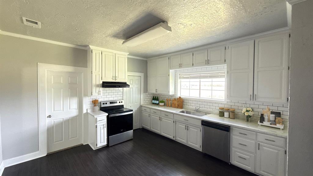 1338 State Highway 121 Bonham, TX 75418 - Photo 28 of 32 a kitchen with granite countertop white cabinets and white appliances