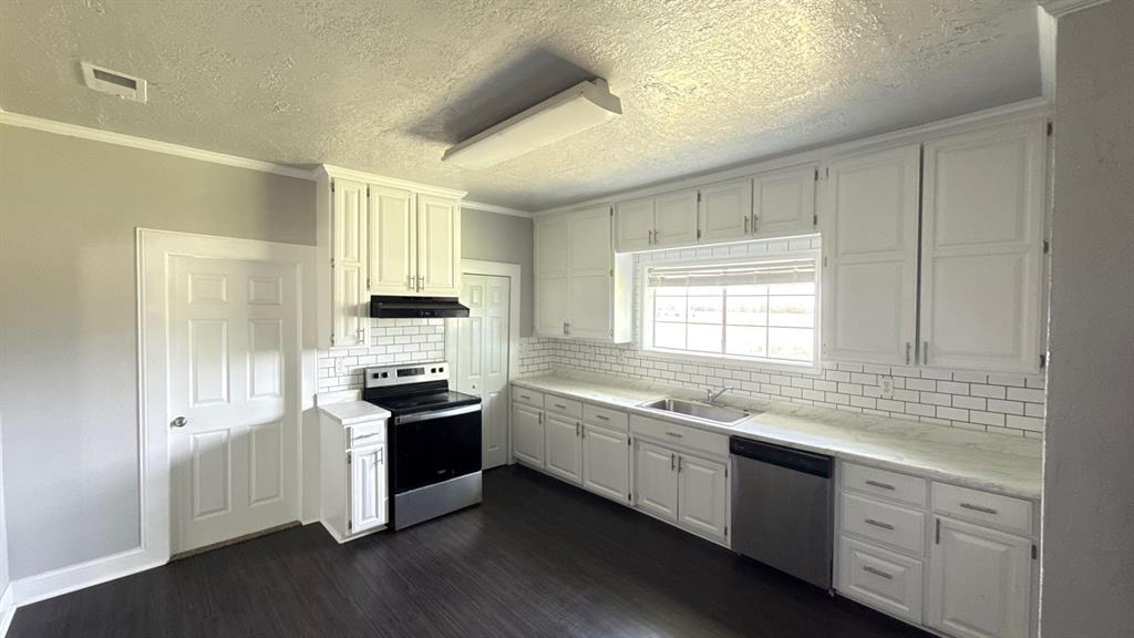 1338 State Highway 121 Bonham, TX 75418 - Photo 12 of 32 a kitchen with granite countertop white cabinets and wooden floor