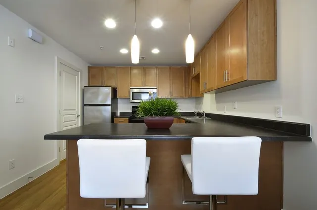 a kitchen with stainless steel appliances granite countertop a sink a refrigerator and a microwave