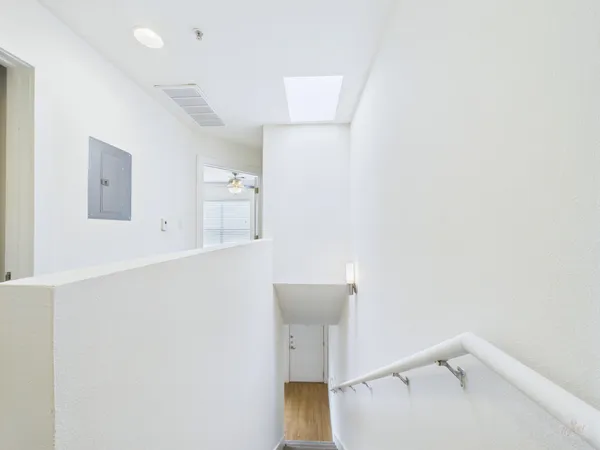 a view of a hallway with wooden floor and staircase