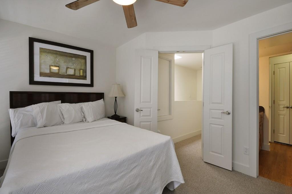 711 West 32nd Street, Unit 108 Austin, TX 78705 - Photo 26 of 28 a bedroom with a bed and a painting on the wall