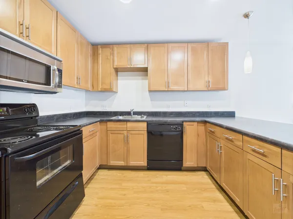a kitchen with stainless steel appliances granite countertop a stove a sink and a microwave