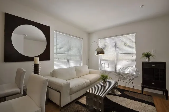 a living room with furniture a window and a flat screen tv