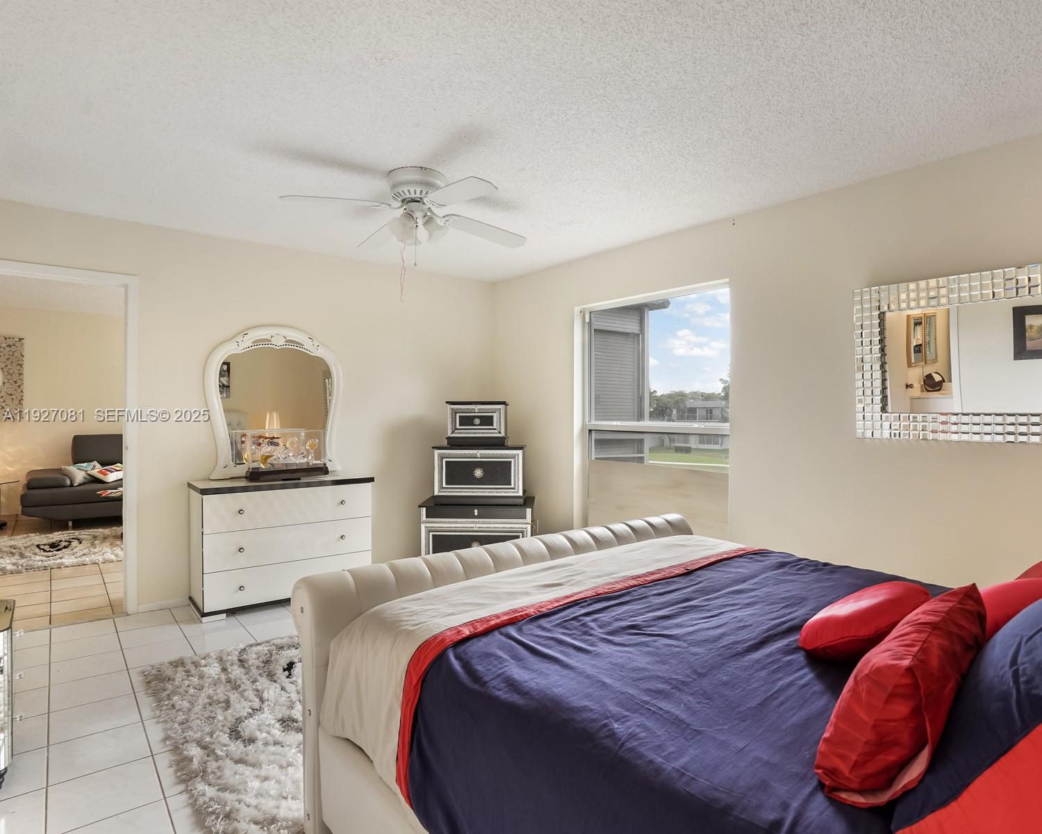 8320 Sands Point Boulevard, Unit M301 Tamarac, FL 33321 - Photo 13 of 36 a bedroom with a bed and dresser with mirror