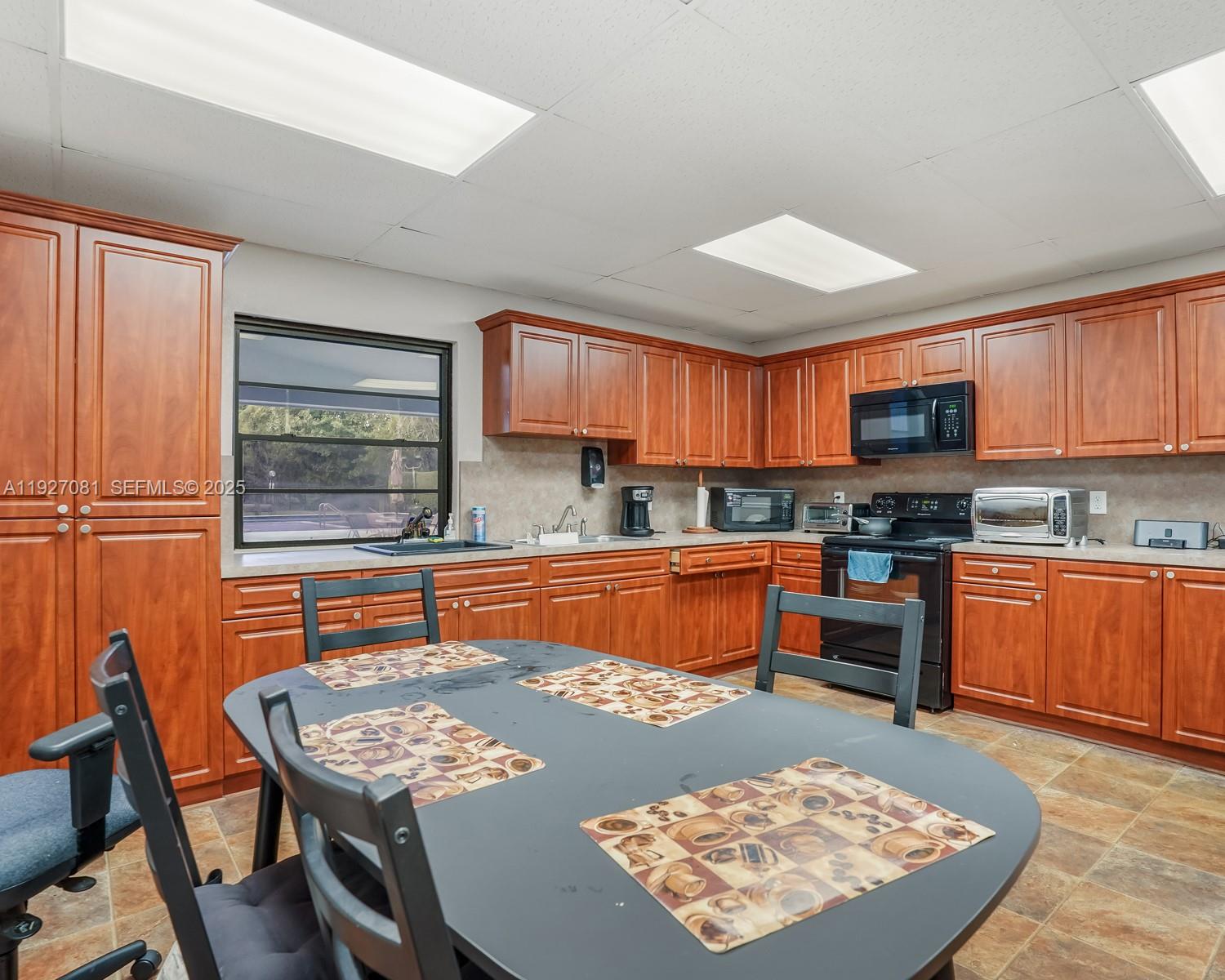 8320 Sands Point Boulevard, Unit M301 Tamarac, FL 33321 - Photo 32 of 36 a kitchen with stainless steel appliances granite countertop a sink stove and refrigerator