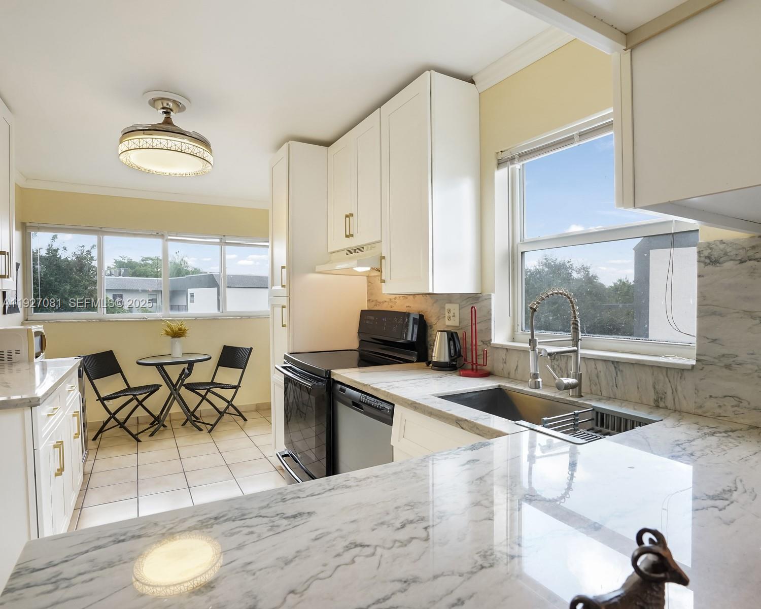 8320 Sands Point Boulevard, Unit M301 Tamarac, FL 33321 - Photo 4 of 36 a kitchen with stainless steel appliances granite countertop a stove a sink and a dining table with granite countertops