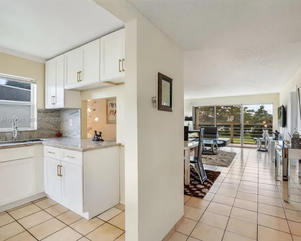 a kitchen with stainless steel appliances granite countertop a sink and a white cabinets