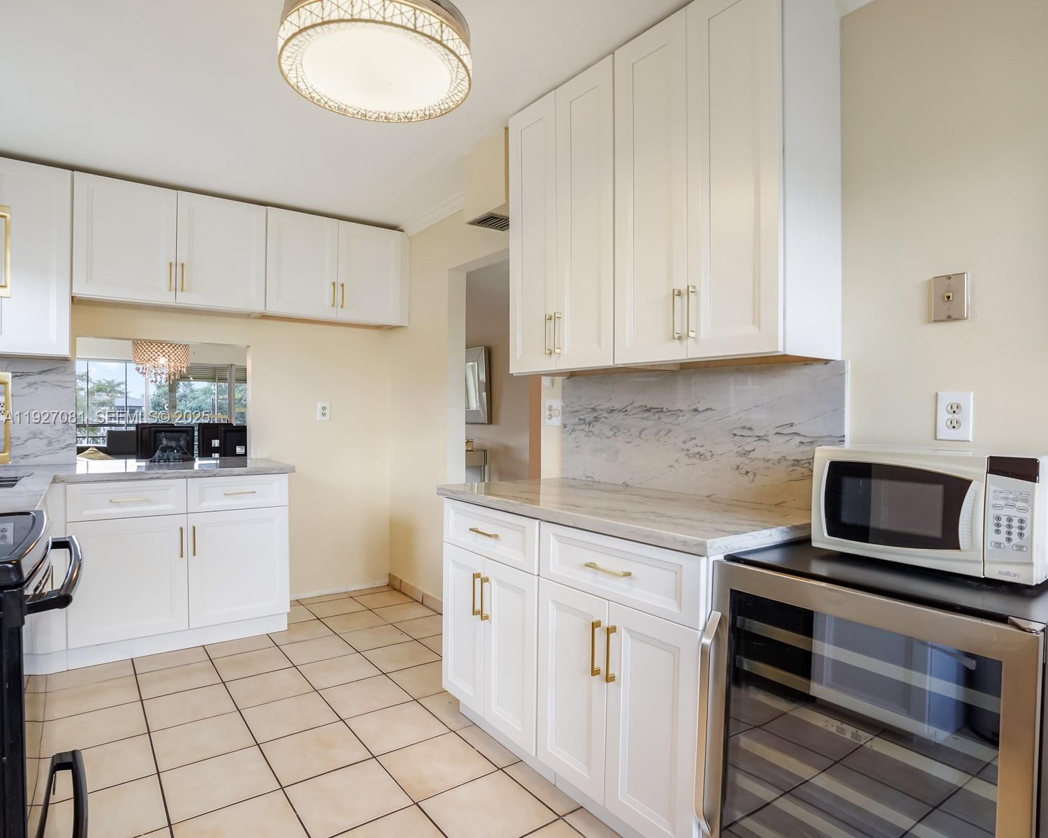 8320 Sands Point Boulevard, Unit M301 Tamarac, FL 33321 - Photo 10 of 36 a kitchen with white cabinets and appliances