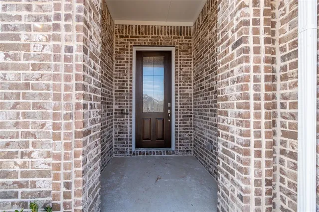 a view of a hallway with wooden floor and a bathroom