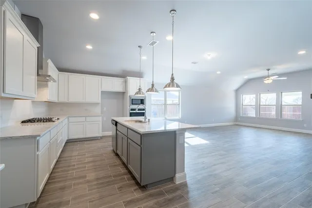 a large kitchen with kitchen island a sink stainless steel appliances and cabinets
