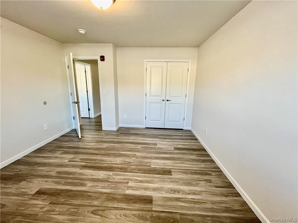 206 Golf Links Road, Unit 821 Middletown, NY 10940 - Photo 4 of 7 Unfurnished bedroom featuring dark wood-type flooring and a closet