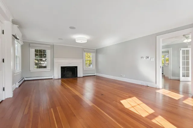 an empty room with wooden floor and fireplace