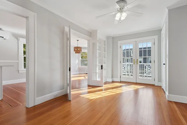 an empty room with wooden floor and windows